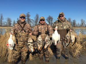 group of men holding harvested specklebelly and snow geese 